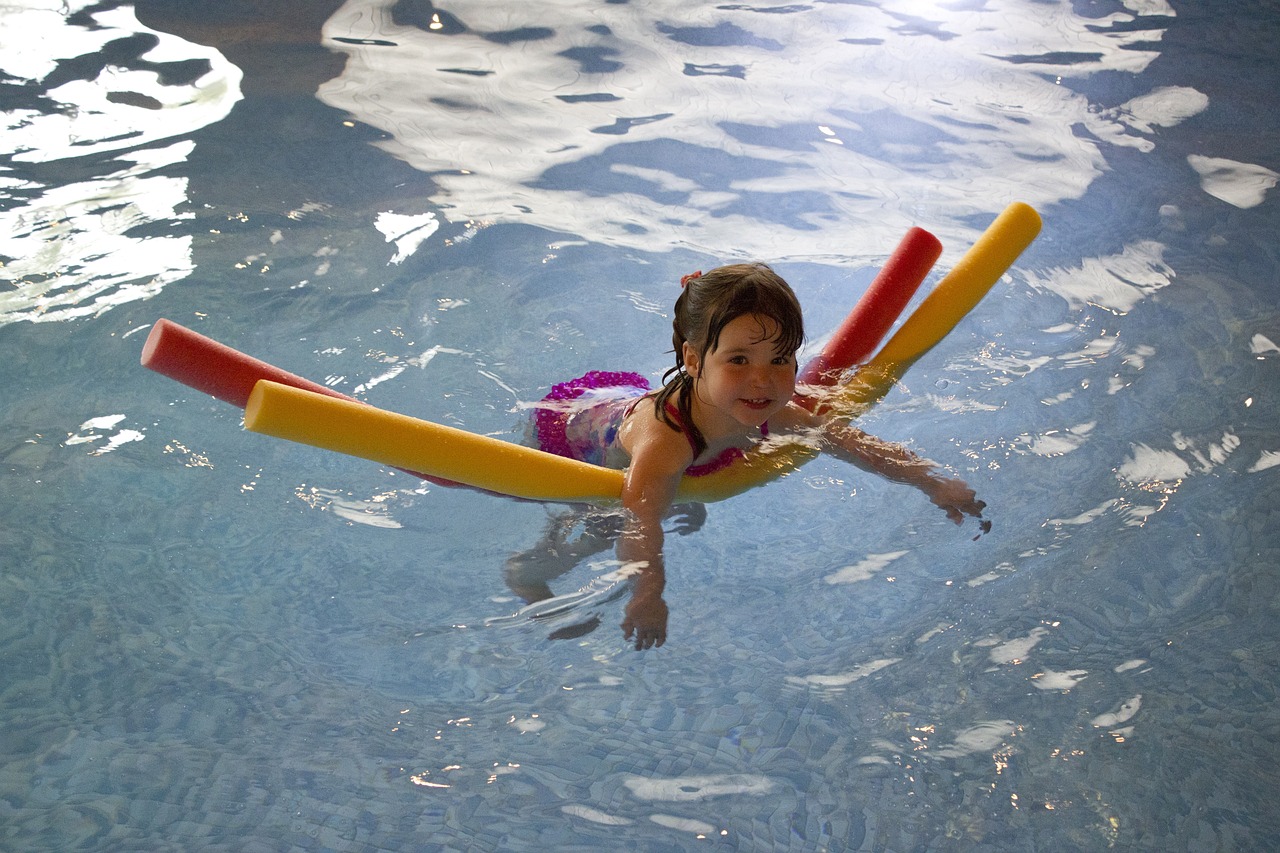 young girl on pool noodle