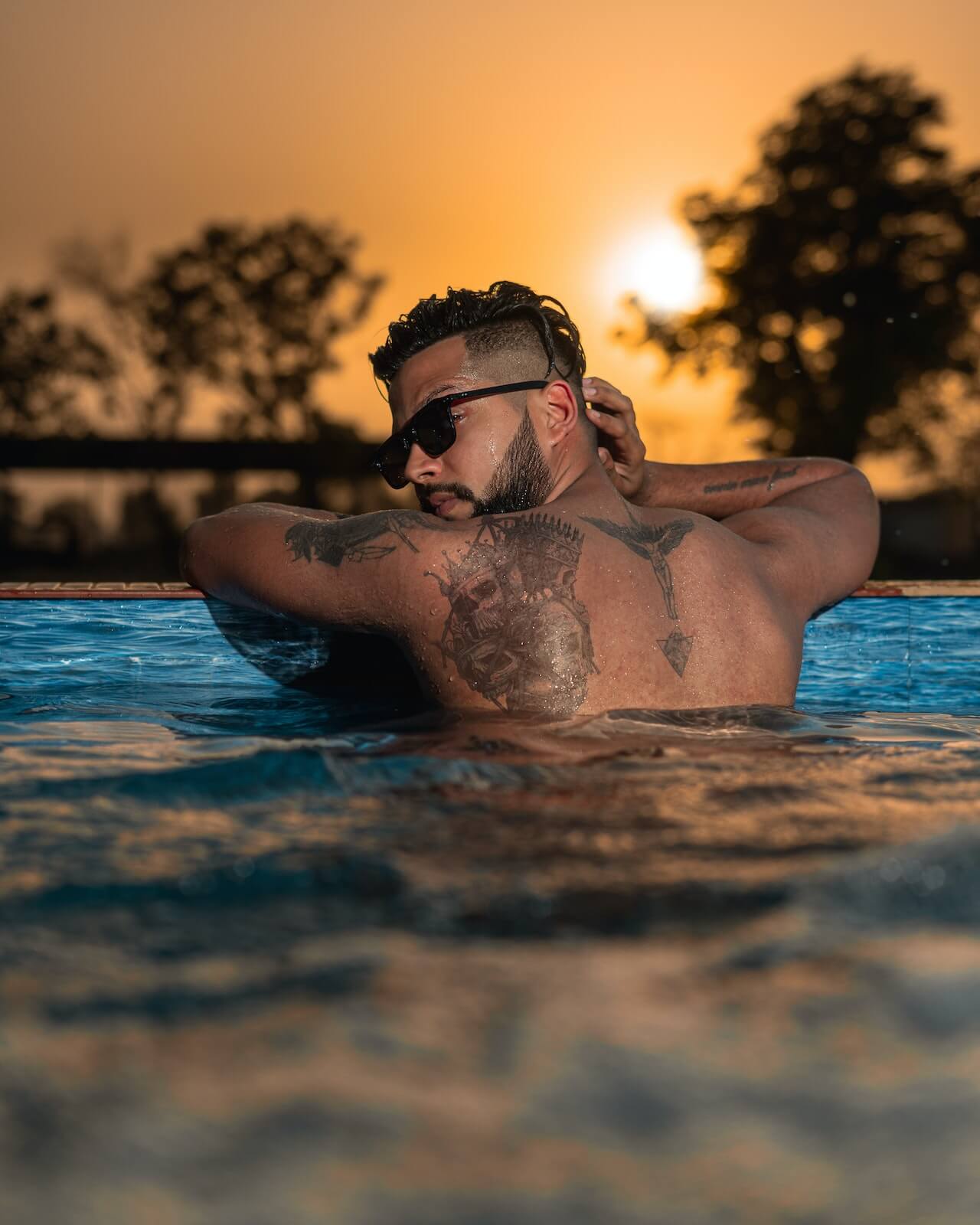 back of a tattooed man in the pool