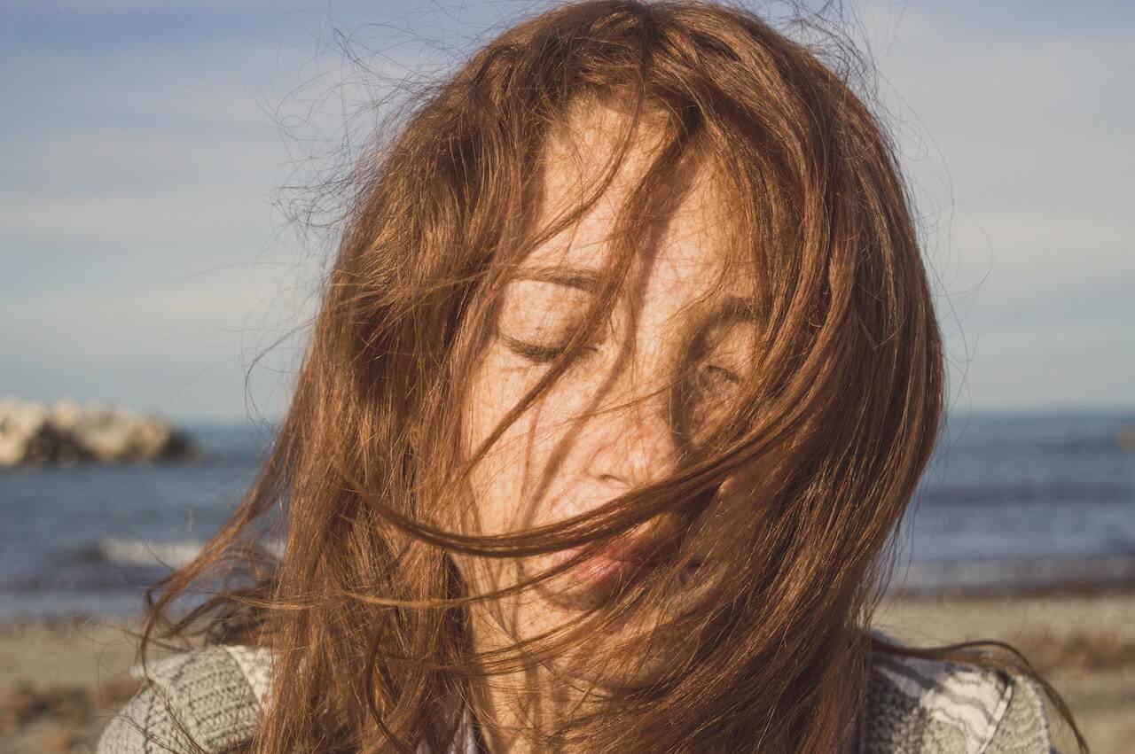 frizzy hair covering woman's face