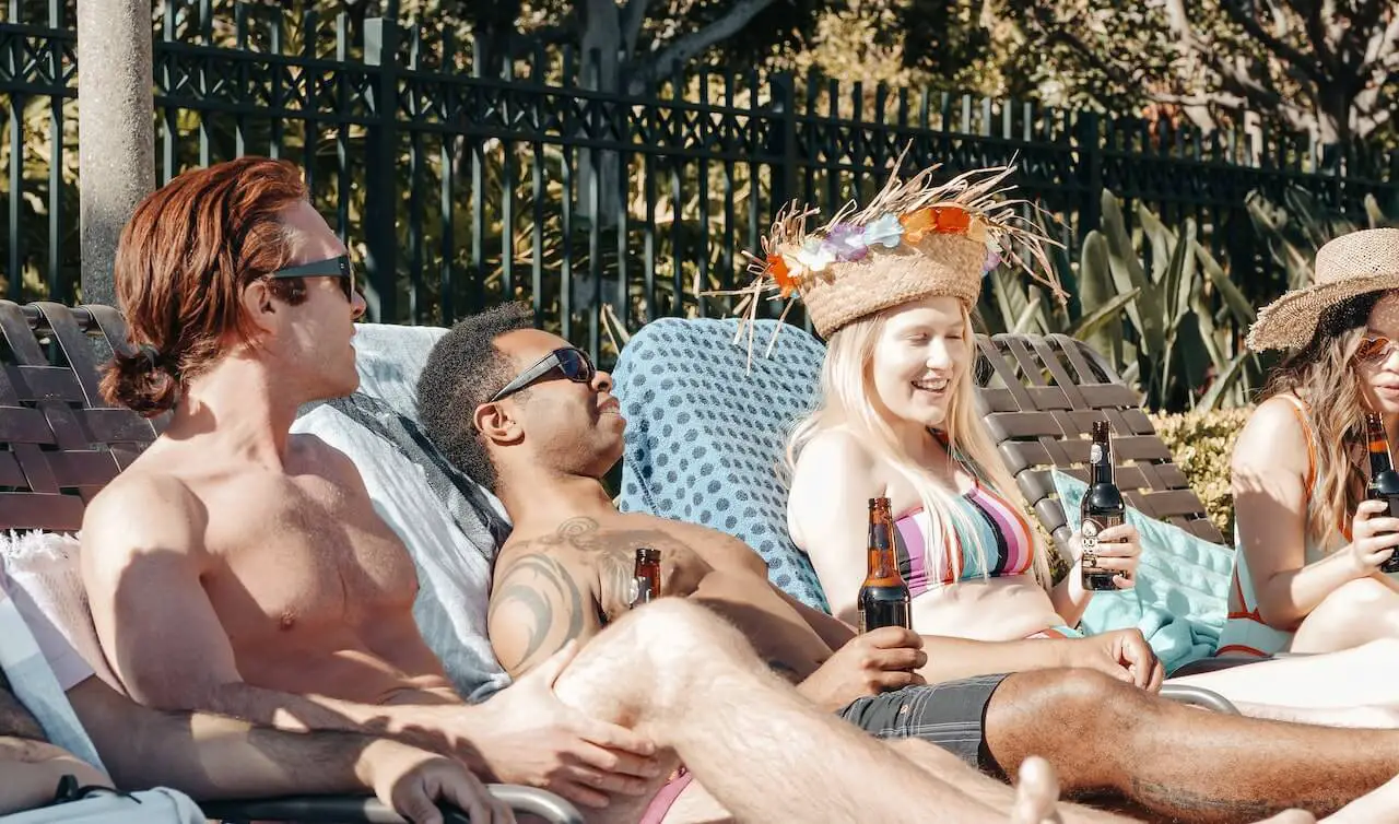 group of friends lounging on chairs by the pool