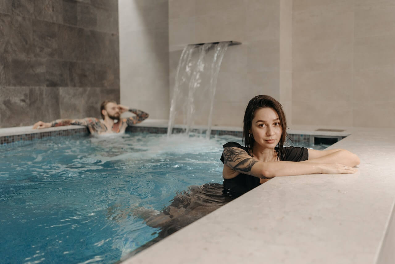 tattooed man and woman in a swimming pool