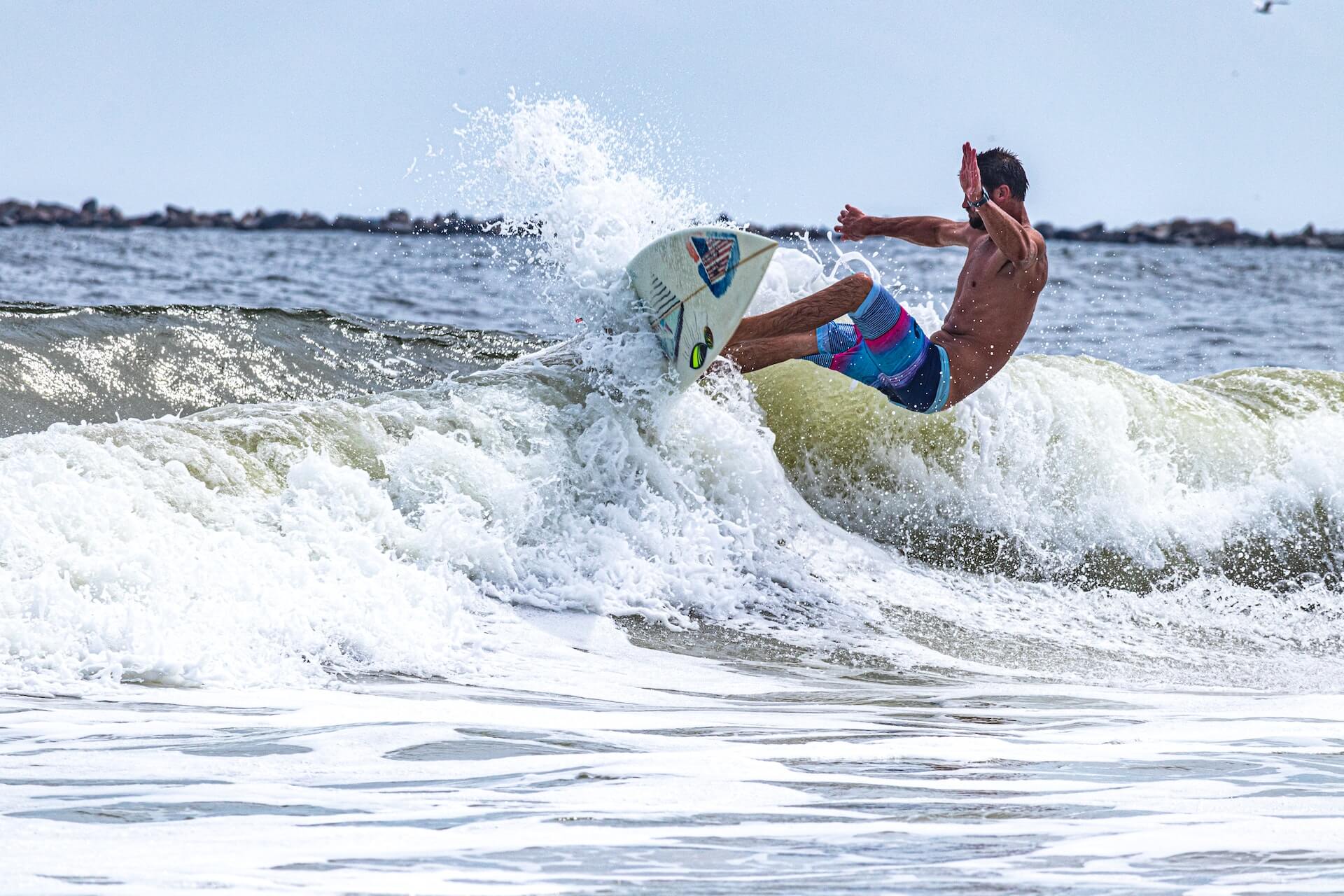 man surfing with board shorts