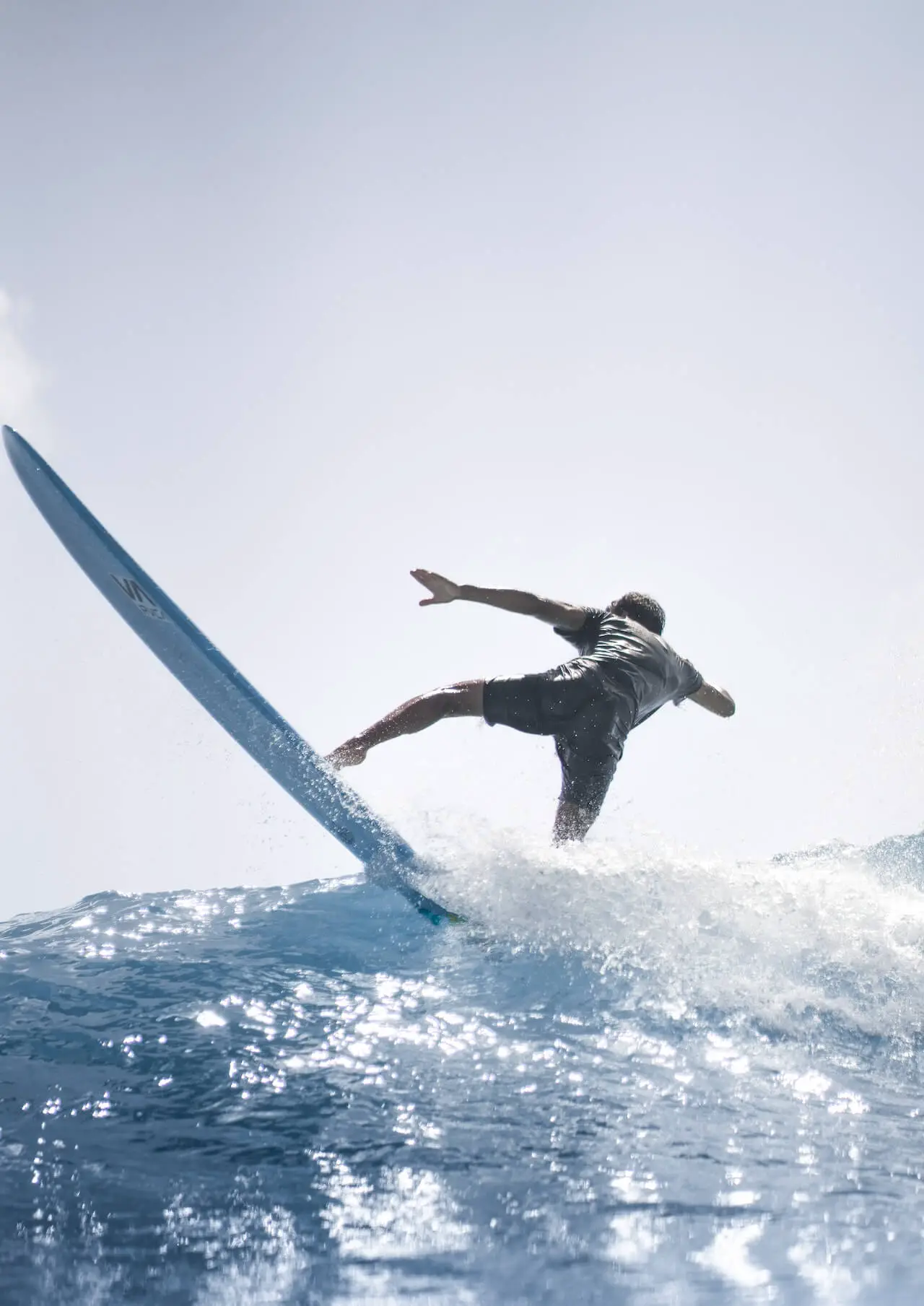 man surfing with rash guard and board shorts