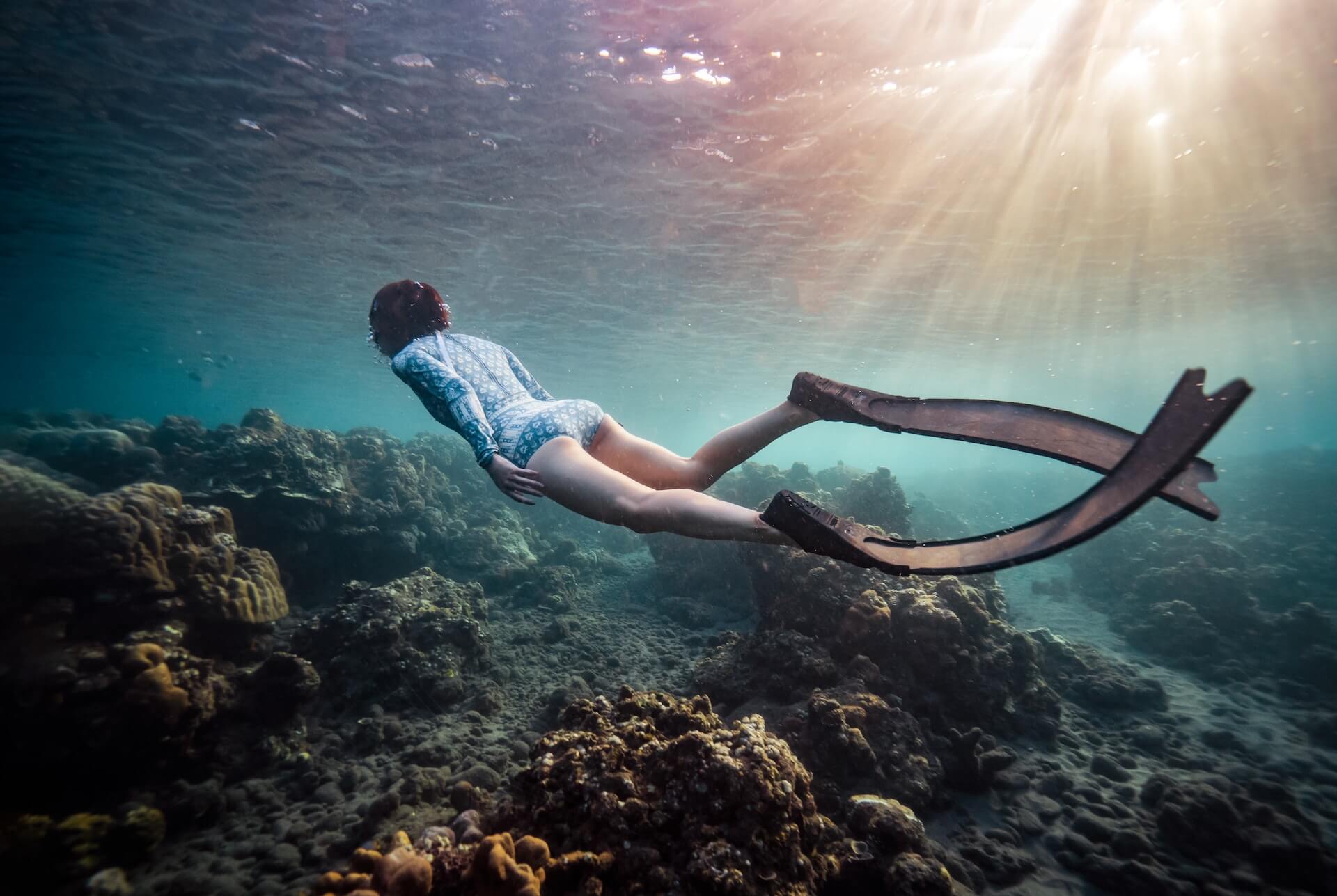 woman diving underwater with freediving fins